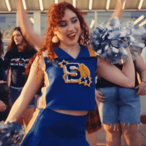 A Cheerleader Wears A Blue Uniform With The Letter S On It GIF