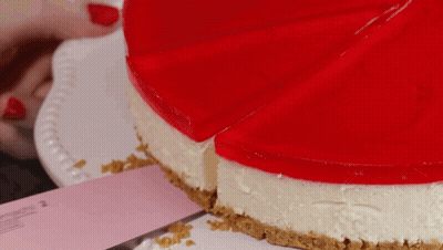 A Cheesecake With A Slice Taken Out Of It On A White Plate GIF