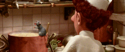 A Chef Is Standing In A Kitchen Looking At A Pot Of Soup With A Rat In It . GIF