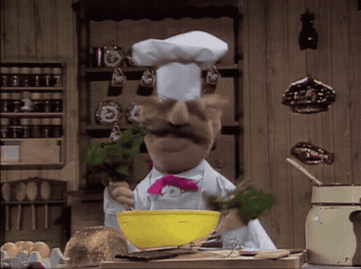 A Chef With A Mustache And A Pink Bow Tie Is Mixing Something In A Yellow Bowl GIF