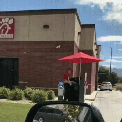 A Chick-Fil-A Drive-Thru With A Red Umbrella In Front Of It GIF