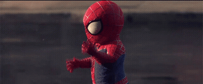 A Child Dressed In A Spiderman Costume Is Walking Down A Street GIF