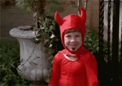 A Child In A Red Devil Costume Is Smiling . GIF