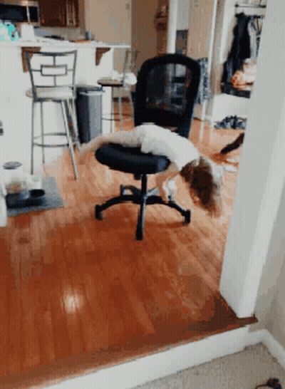 A Child Is Laying On A Chair In A Room GIF