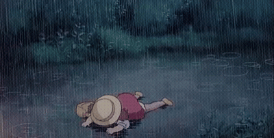 A Child Is Laying On The Ground In The Rain . GIF