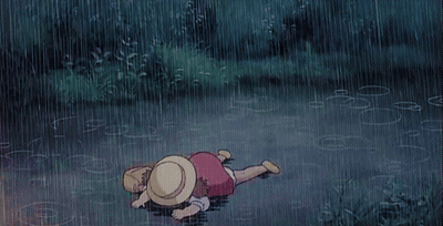 A Child Is Laying On The Ground In The Rain GIF
