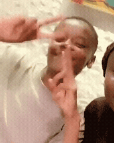 A Child Is Making A Peace Sign With His Finger GIF