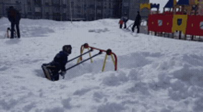 A Child Is Playing In The Snow With A Sled GIF