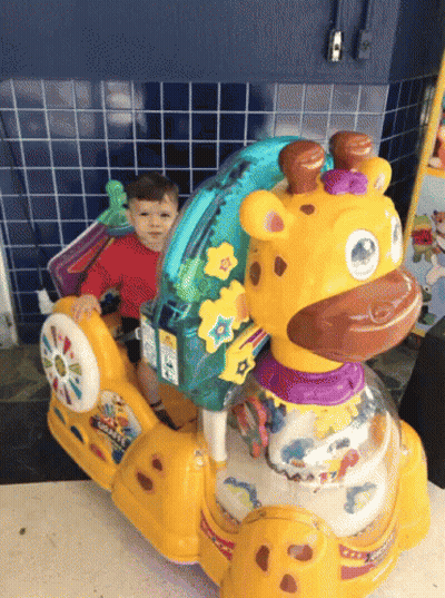 A Child Is Sitting On A Giraffe Rocker Toy GIF