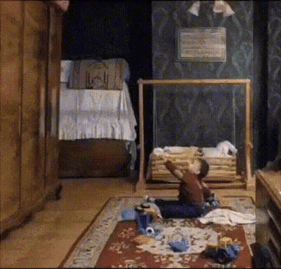 A Child Is Sitting On The Floor In A Room GIF