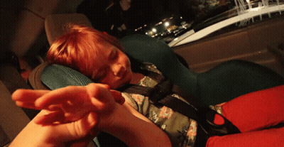 A Child Is Sleeping In A Car Seat With A Hand Reaching Out GIF
