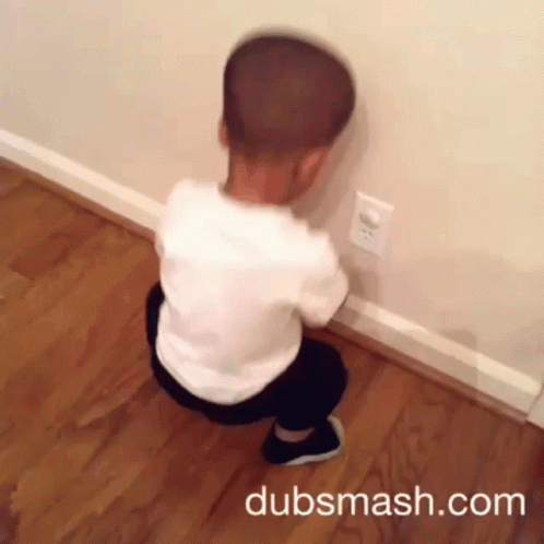 A Child Is Squatting Down In Front Of A Wall With Dubsmash.com Written On The Bottom Right GIF