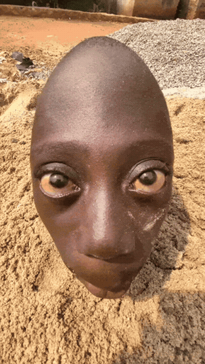A Child 'S Head Is Buried In Sand And Looks Like An Egg GIF