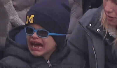 A Child Wearing A Hat With The Letter M On It Is Crying GIF