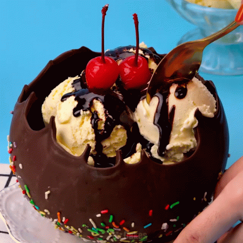 A Chocolate Bowl Filled With Ice Cream And Cherries GIF