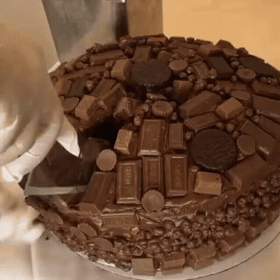 A Chocolate Cake Is Being Decorated With Hershey Candy Bars GIF