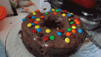 A Chocolate Cake With M & M 'S And A Number 5 On Top GIF