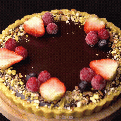 A Chocolate Cake With Strawberries Raspberries And Blueberries GIF