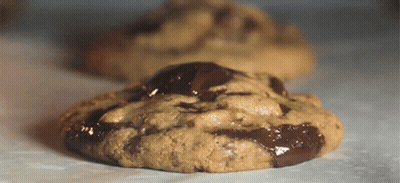 A Chocolate Chip Cookie Is Sitting On A Table GIF