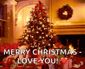A Christmas Tree Is Sitting In Front Of A Fireplace In A Living Room . GIF