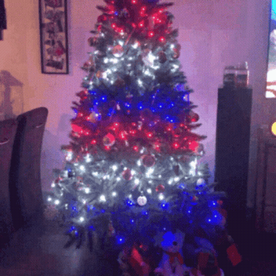 A Christmas Tree With Red White And Blue Lights And Decorations GIF