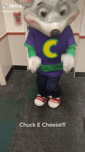 A Chuck E Cheese Mascot Is Standing On A Tiled Floor GIF