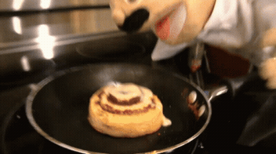 A Cinnamon Roll Is Being Cooked In A Pan GIF