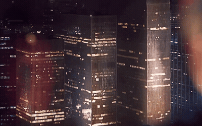A City Skyline At Night With A Few Buildings Including One That Says ' A ' On The Top GIF