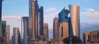A City Skyline With A Blue Sky And A Few Clouds In The Background GIF