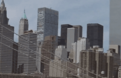 A City Skyline With A Bridge In The Foreground And One Of The Buildings Has The Word Brooklyn On The Top Of It GIF