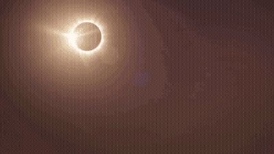 A City Skyline With A Partial Eclipse Of The Sun GIF