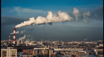 A Cityscape With Smoke Coming Out Of A Factory GIF
