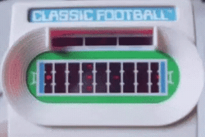 A Classic Football Game Is Being Played On A Table . GIF
