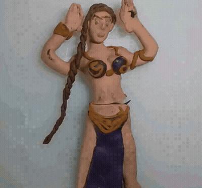 A Clay Figure Of A Woman With Braids And A Purple Skirt GIF
