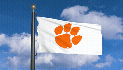 A Clemson Flag Is Flying In The Wind Against A Blue Sky GIF