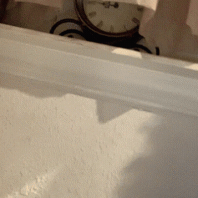 A Clock On A White Wall Shows The Time As Almost 5:00 GIF