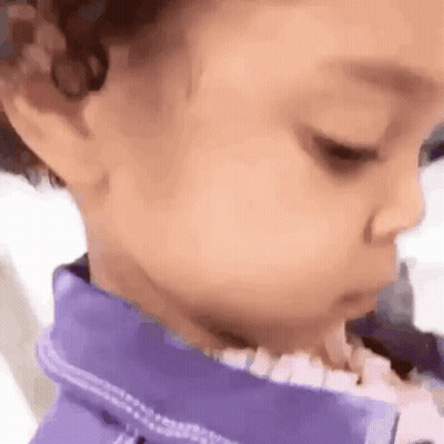 A Close Up Of A Baby 'S Face Wearing A Purple Shirt . GIF