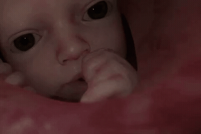 A Close Up Of A Baby 'S Face With A Person 'S Finger In It GIF