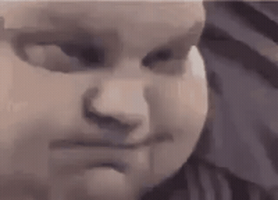 A Close Up Of A Baby 'S Face With A Serious Look On His Face . GIF