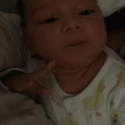 A Close Up Of A Baby 'S Face With A White Shirt On GIF
