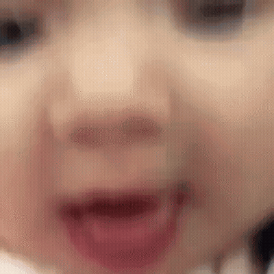 A Close Up Of A Baby 'S Face With Its Mouth Open And Teeth Visible . GIF