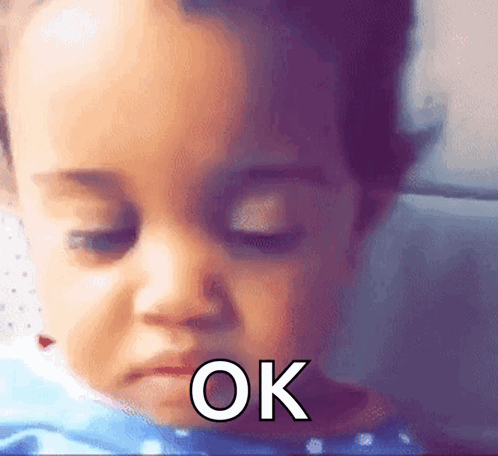 A Close Up Of A Baby 'S Face With The Word Ok Written On It GIF