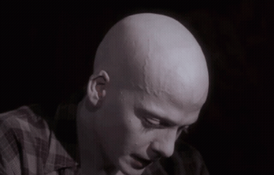 A Close Up Of A Bald Man 'S Head With A Plaid Shirt On GIF
