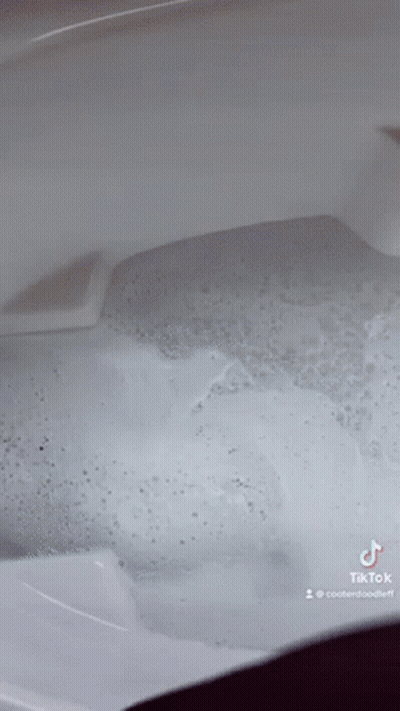 A Close Up Of A Bathtub Filled With Bubbles And Water . GIF