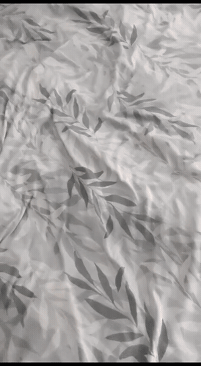 A Close Up Of A Bedspread With A Leafy Pattern GIF