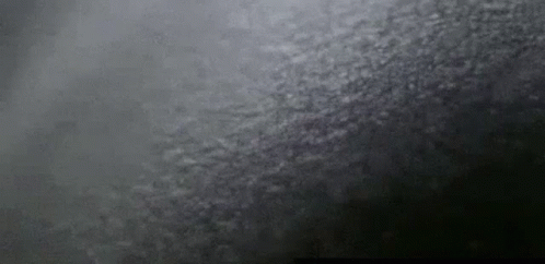 A Close Up Of A Black Background With A Gray Texture And A Few White Clouds . GIF