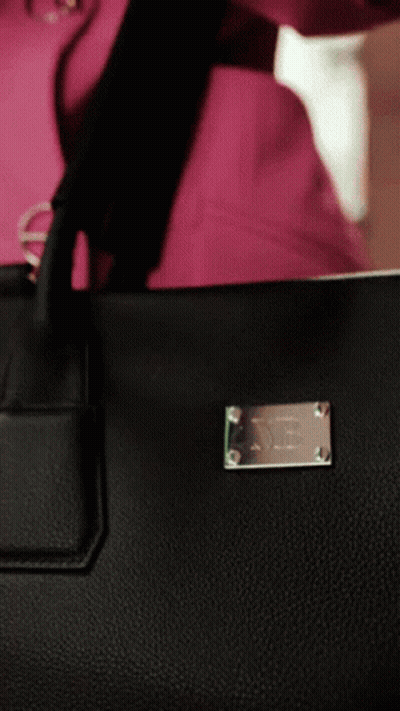 A Close Up Of A Black Purse With A Silver Plaque That Says ' X ' On It GIF