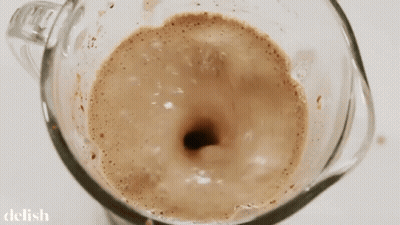 A Close Up Of A Blender Filled With A Brown Liquid GIF