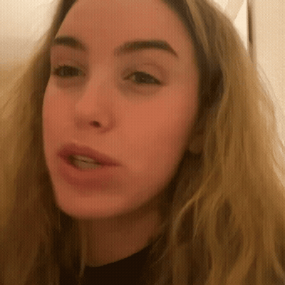 A Close Up Of A Blonde Woman 'S Face With A Black Shirt On GIF