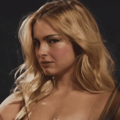 A Close Up Of A Blonde Woman 'S Face With A Dark Background GIF